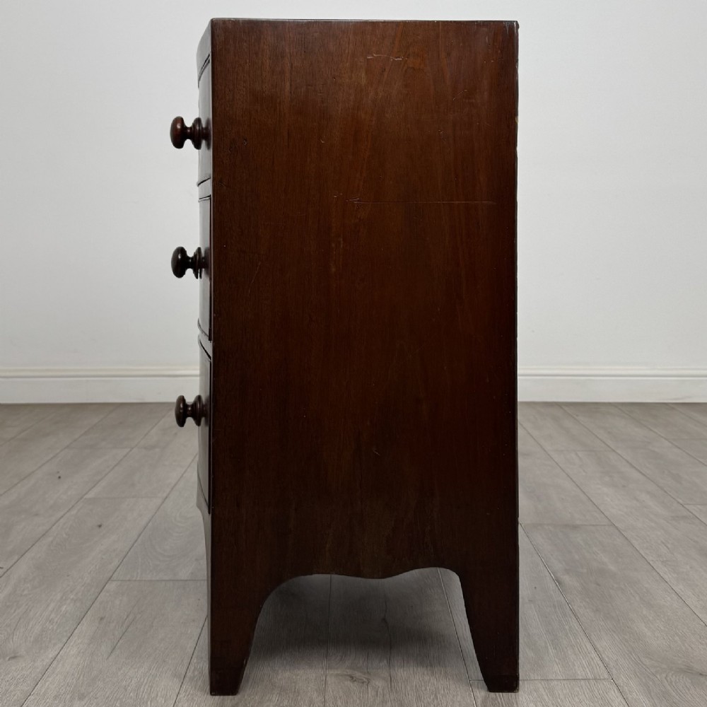 A 19th-century dark mahogany bow front chest of drawers featuring two short drawers above two long drawers with turned wooden handles and bracket feet. View III