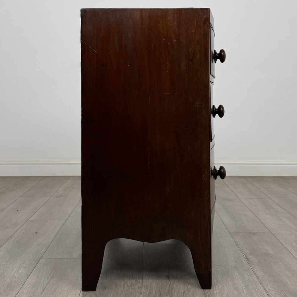 A 19th-century dark mahogany bow front chest of drawers featuring two short drawers above two long drawers with turned wooden handles and bracket feet. View VII
