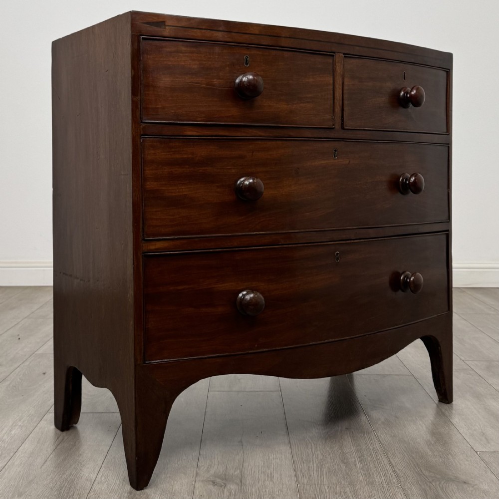 A 19th-century dark mahogany bow front chest of drawers featuring two short drawers above two long drawers with turned wooden handles and bracket feet. View VIII