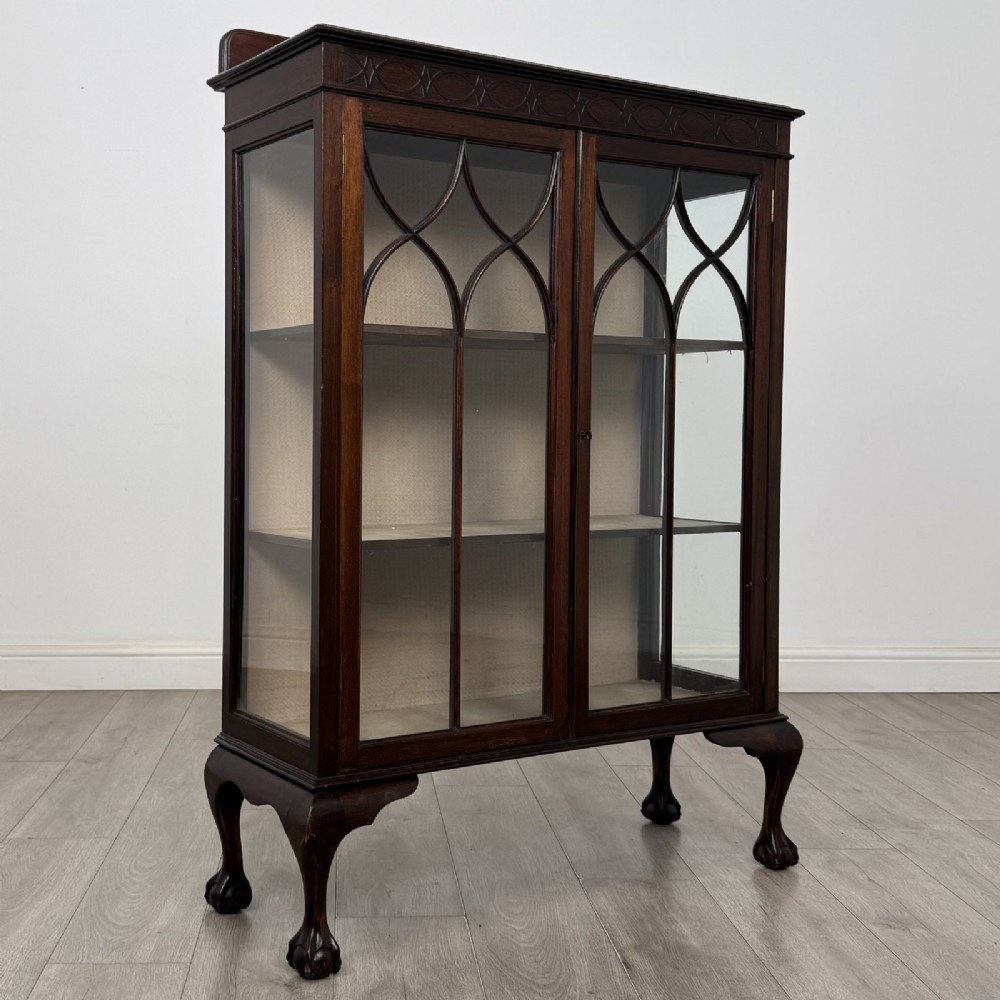 A dark mahogany display cabinet featuring two glazed doors with geometric arch bars and carved ball-and-claw feet. View VIII