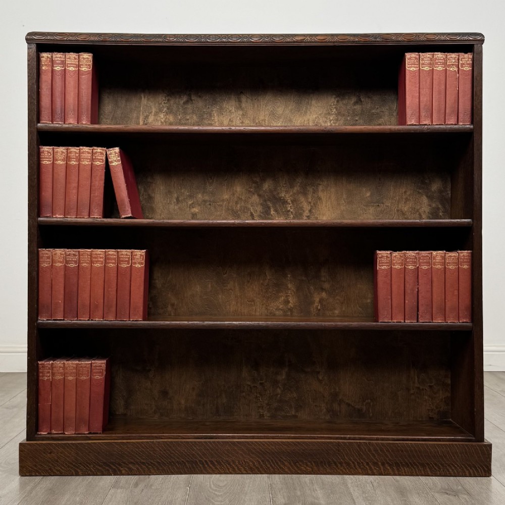 A dark oak open bookcase featuring four tier adjustable shelves and carved moulding along the top frieze. View II