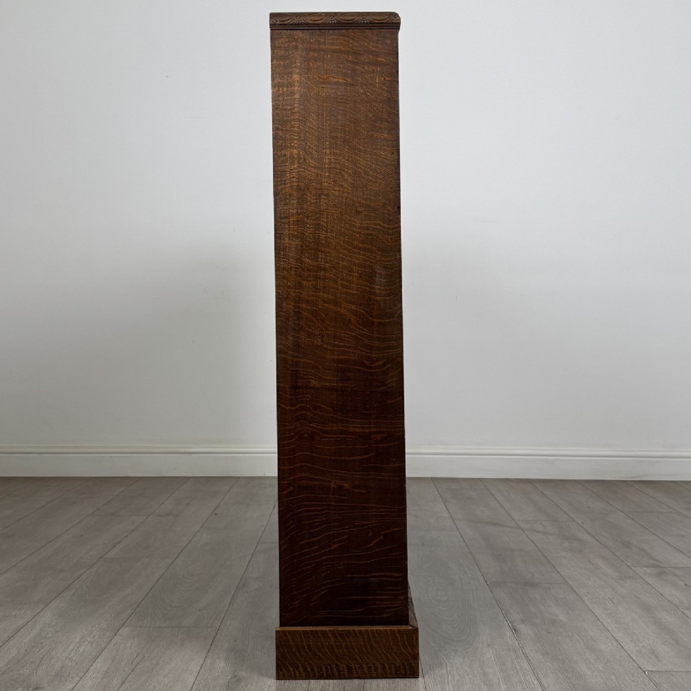 A dark oak open bookcase featuring four tier adjustable shelves and carved moulding along the top frieze. View VIII