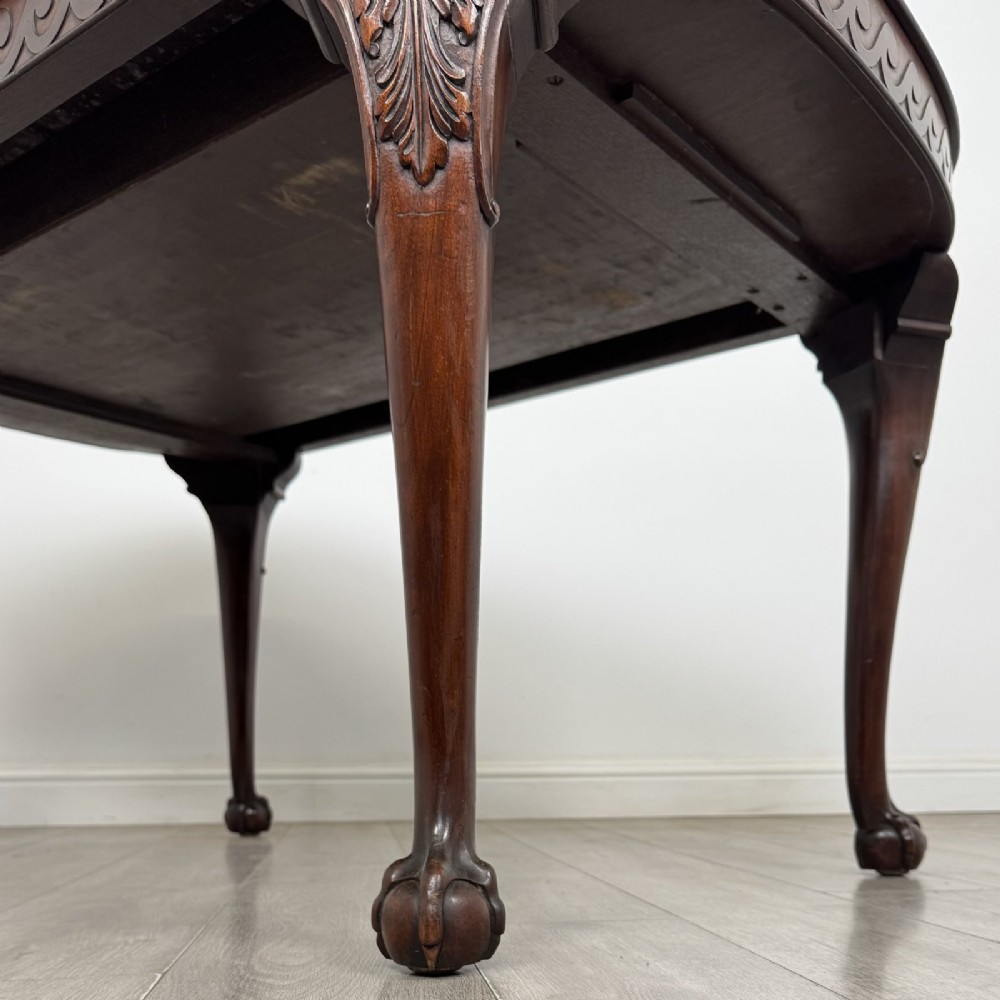 An Edwardian mahogany extending dining table featuring a carved frieze and cabriole legs terminating in ball-and-claw feet. View XI