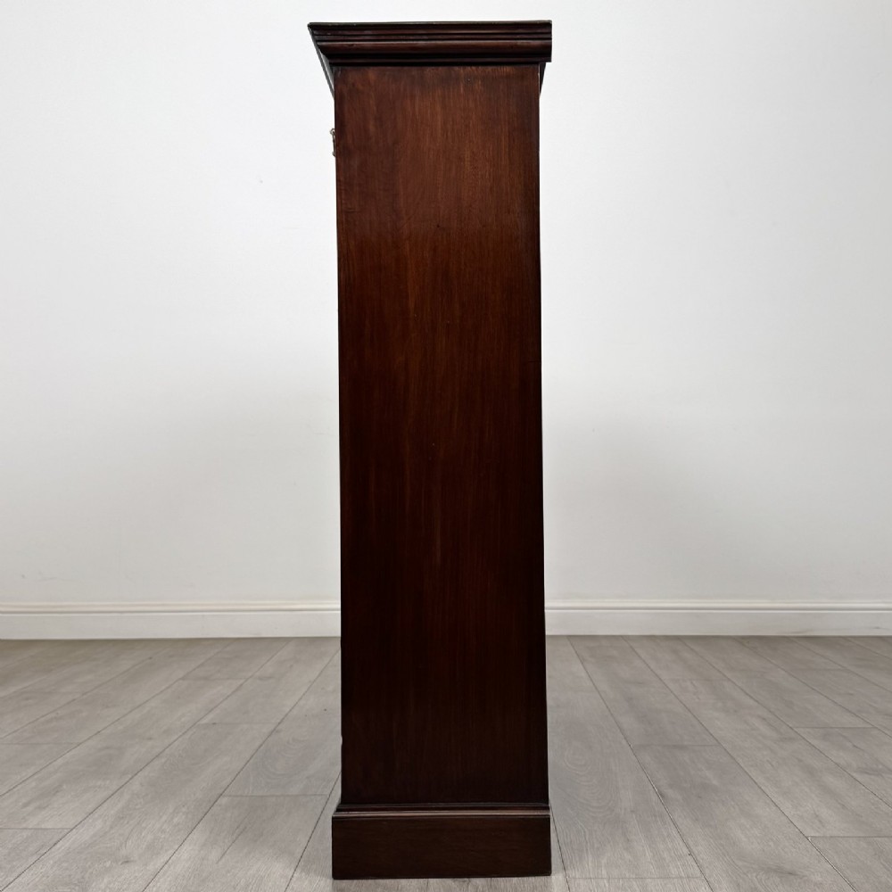 An Edwardian dark mahogany open bookcase featuring three frieze drawers with brass drop handles and three adjustable wooden shelves above a plinth base. View IV