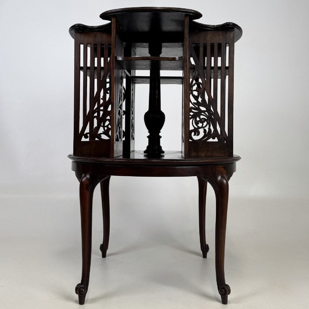 An Edwardian dark mahogany revolving bookcase with pierced foliage fretwork side panels and cabriole legs. View III