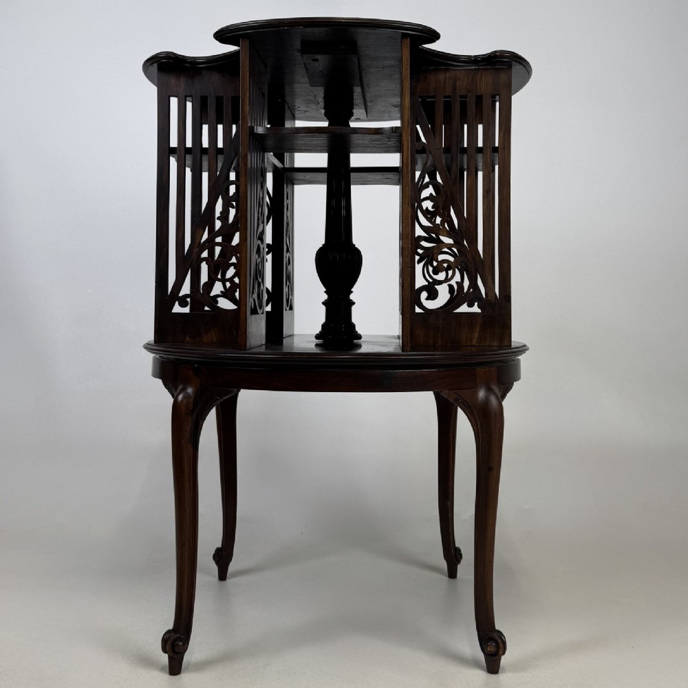 An Edwardian dark mahogany revolving bookcase with pierced foliage fretwork side panels and cabriole legs. View V