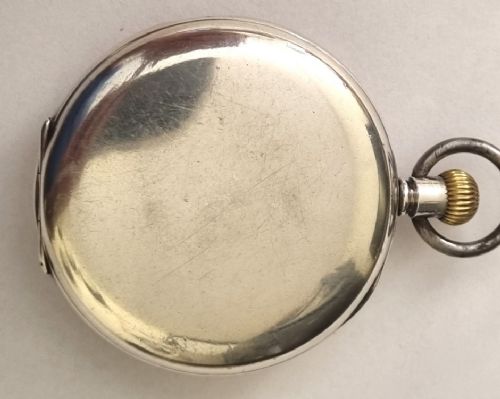 fig 1. A silver cased half hunter pocket watch featuring an outer ring of Roman numerals surrounding a central circular aperture revealing the dial and hands.