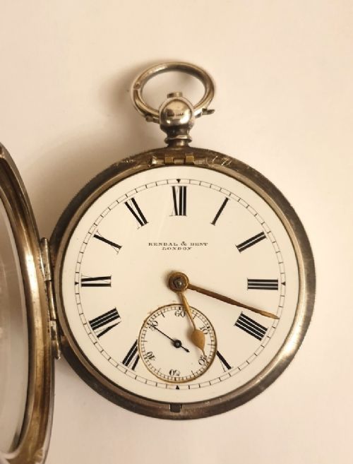 fig 1. An antique silver open-face key-wind pocket watch featuring a white enamel dial with black Roman numerals, gold-tone spade hands, and a subsidiary seconds sub-dial.