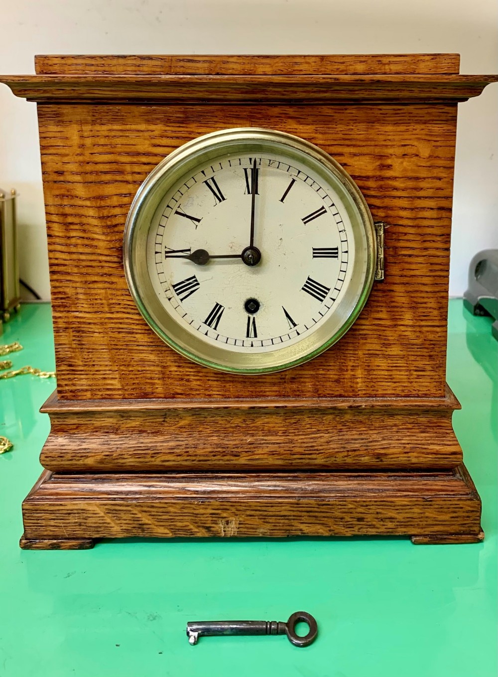 A late 19th-century English fusee mantel clock featuring a rectangular oak case with tiered moulding and a white dial displaying Roman numerals.
