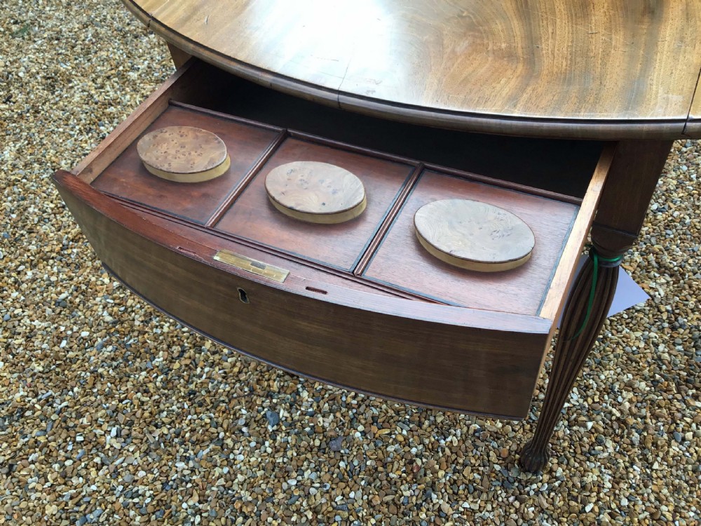 A Sheraton style mahogany Pembroke table with an oval top, drop leaves, a single drawer, and four slender reeded legs. View II