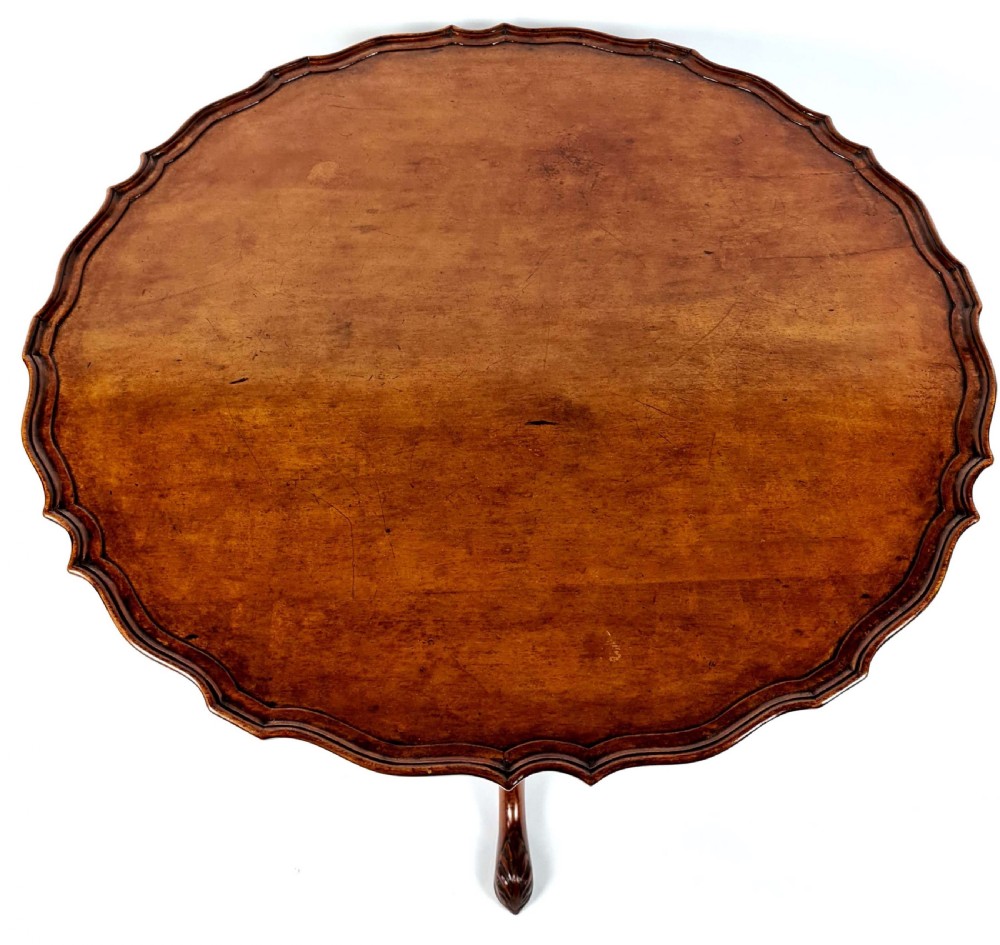 A 19th-century mahogany tripod table with a piecrust scalloped top, turned central column, and three carved cabriole legs. View II