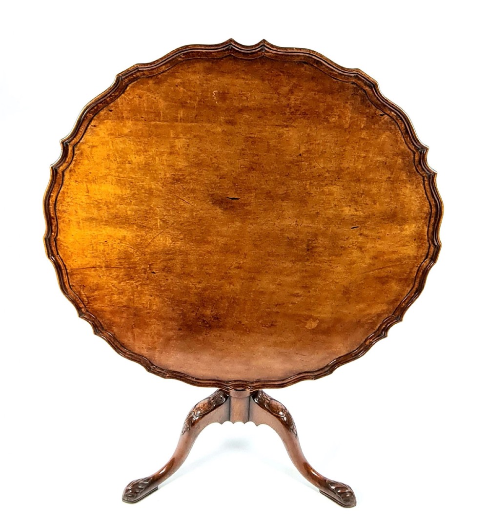 A 19th-century mahogany tripod table with a piecrust scalloped top, turned central column, and three carved cabriole legs. View IV