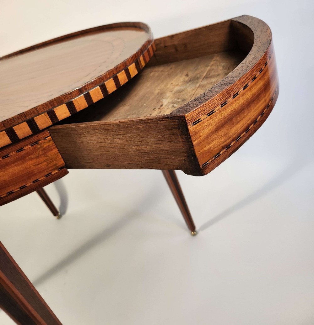 An 18th-century Dutch oval satinwood side table with inlaid geometric banding around the rim and apron, supported by four tapered square legs with brass feet. View III