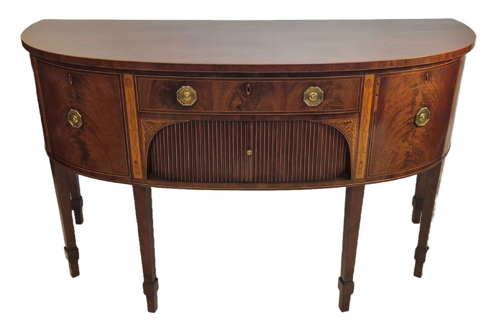 A George III mahogany bow-fronted sideboard featuring flame mahogany drawer fronts, boxwood inlay, and tapered square legs.