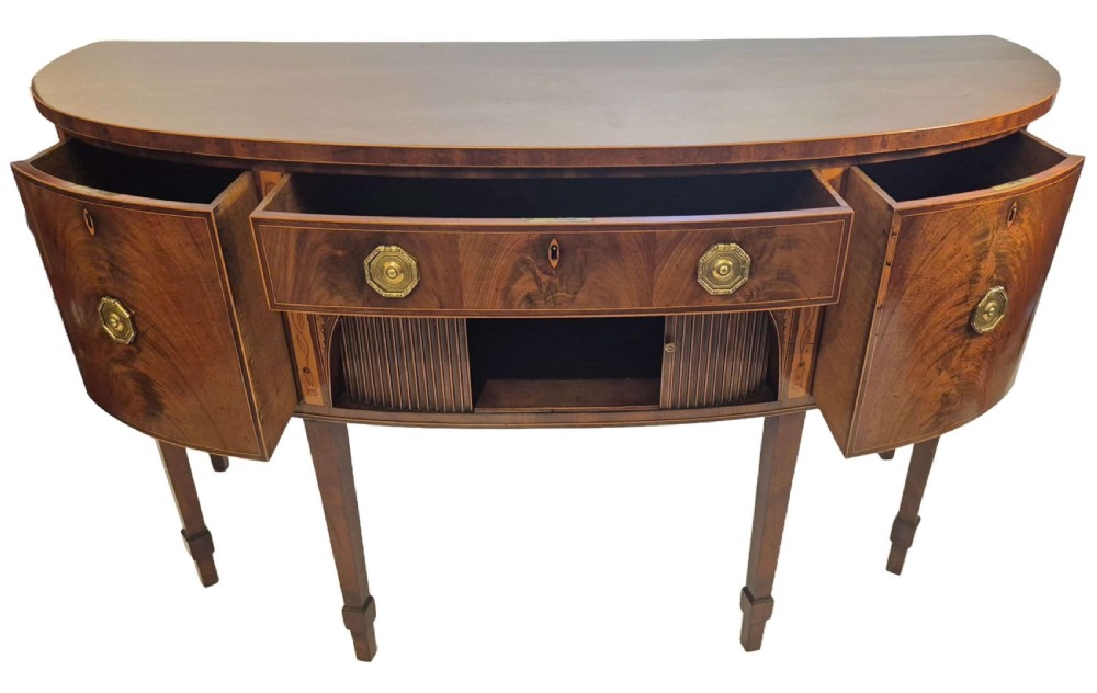 A George III mahogany bow-fronted sideboard featuring flame mahogany drawer fronts, boxwood inlay, and tapered square legs. View III