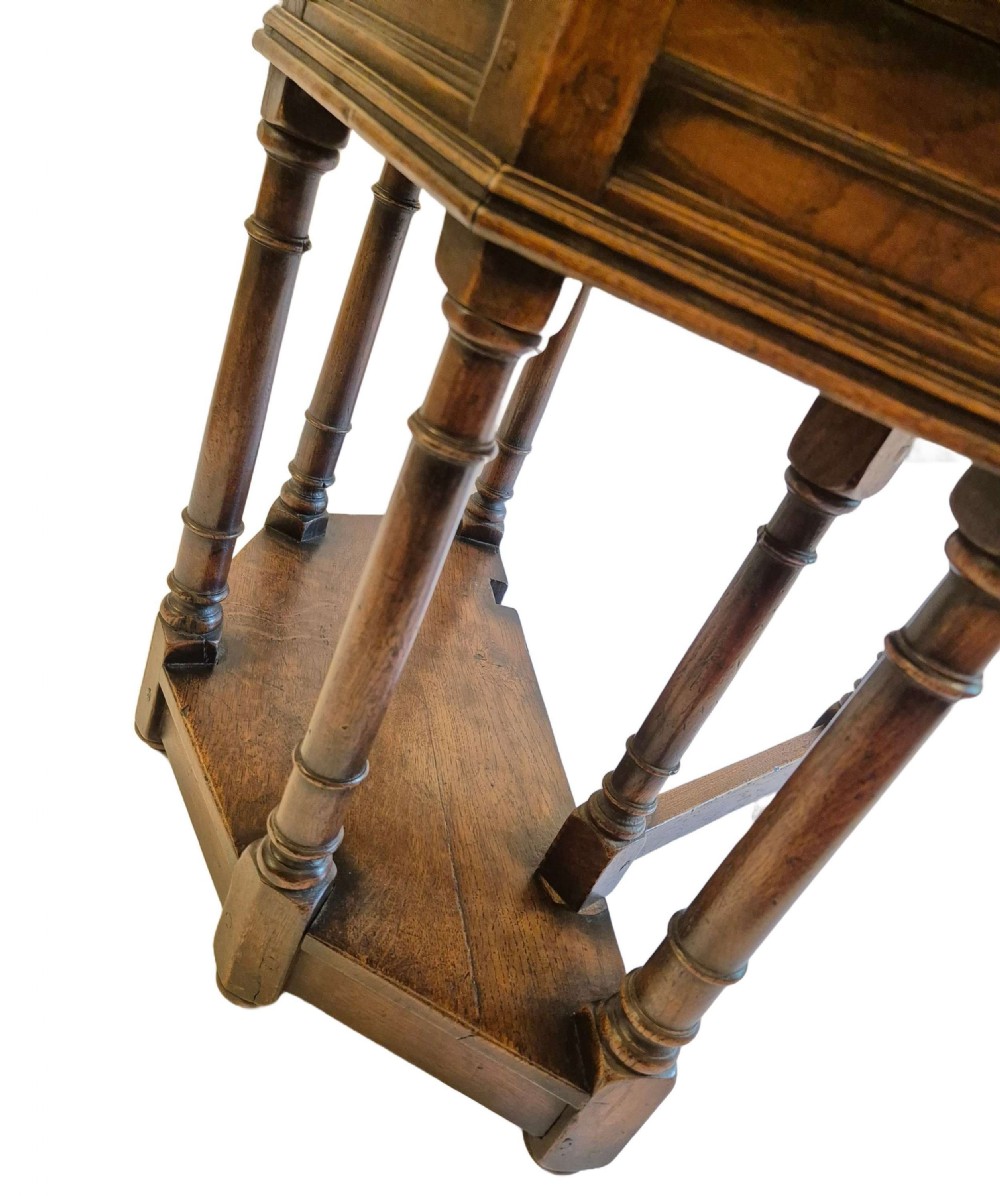 A dark oak credence side table featuring a canted top, turned column legs, a lower shelf, and a fold-over leaf mechanism. View III