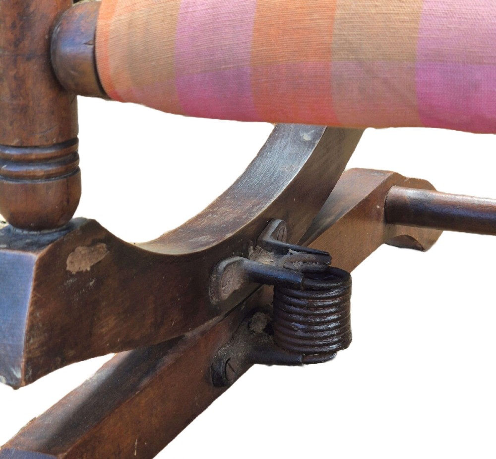 An antique childs fruitwood platform rocking chair featuring turned spindle arms, bobbin details, and orange and pink checked upholstery. View III