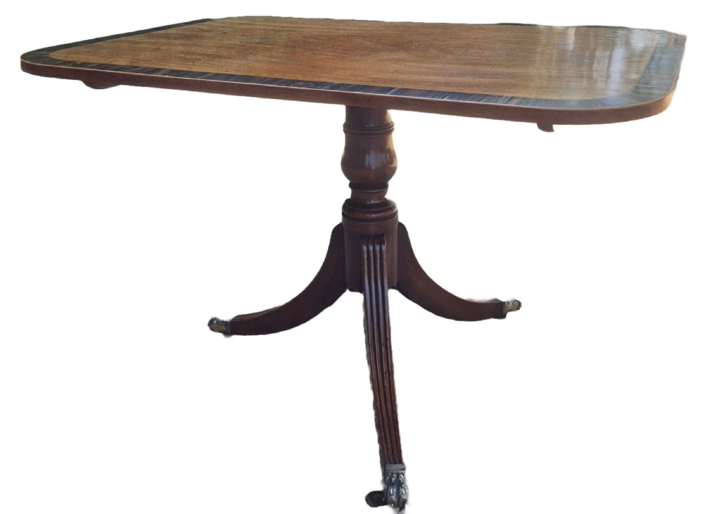 A George III mahogany tilt-top supper table featuring wide crossbanding, reeded tripod legs, and brass paw feet. View II