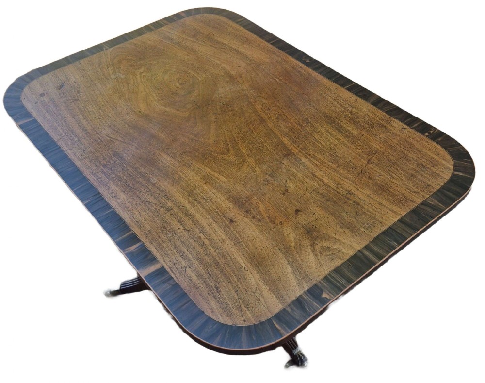 A George III mahogany tilt-top supper table featuring wide crossbanding, reeded tripod legs, and brass paw feet. View III