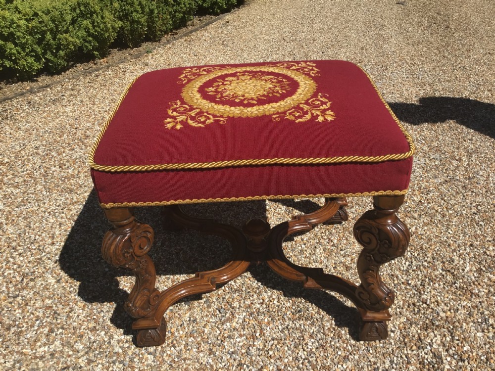 Pair of rectangular mid-19th century footstools featuring burgundy fabric with gold embroidered central medallions and carved wooden legs with stretchers. View II