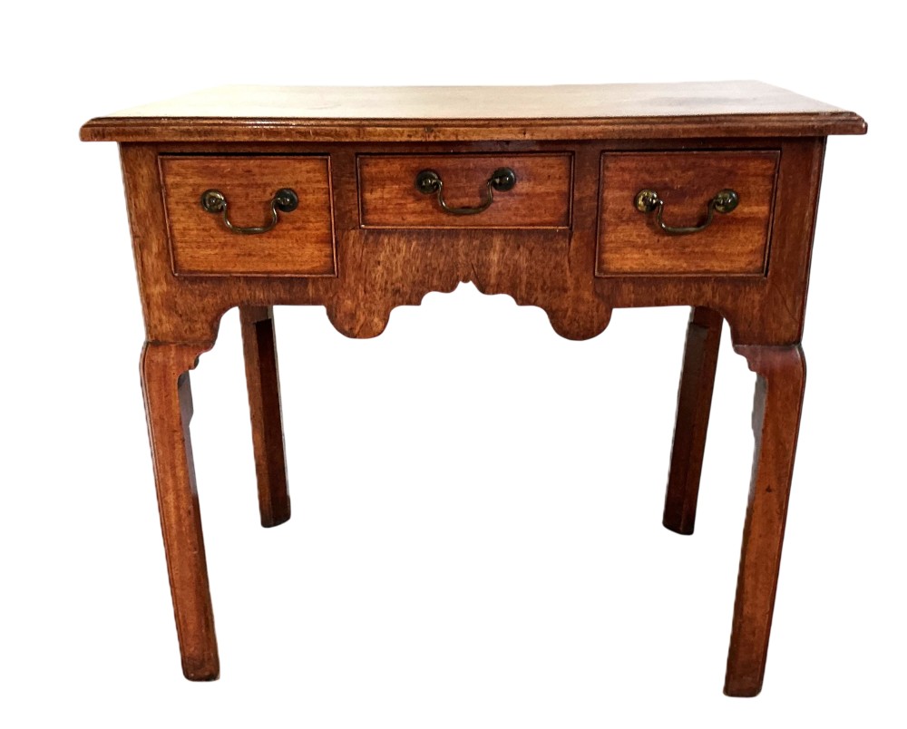 Mid-18th-century Georgian mahogany side table featuring three drawers, brass handles, a shaped apron, and four square legs. View II