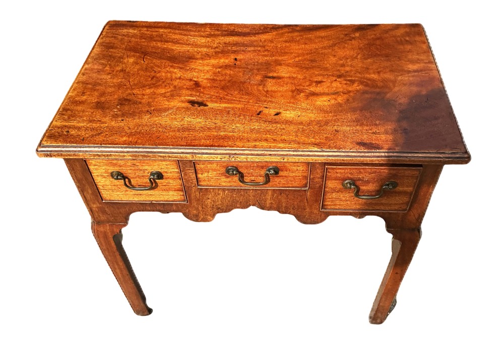 Mid-18th-century Georgian mahogany side table featuring three drawers, brass handles, a shaped apron, and four square legs. View III