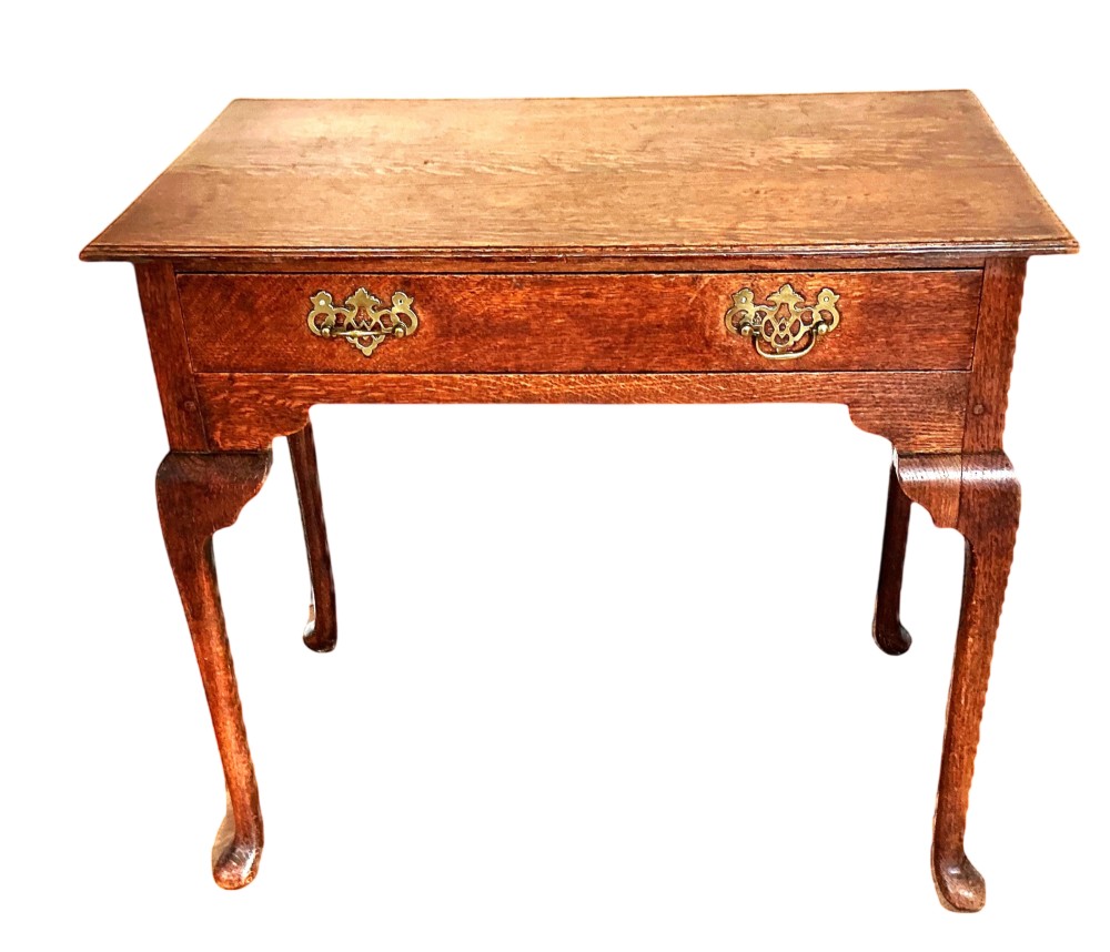 A George III rectangular oak side table featuring a single drawer with brass backplate handles and cabriole legs.