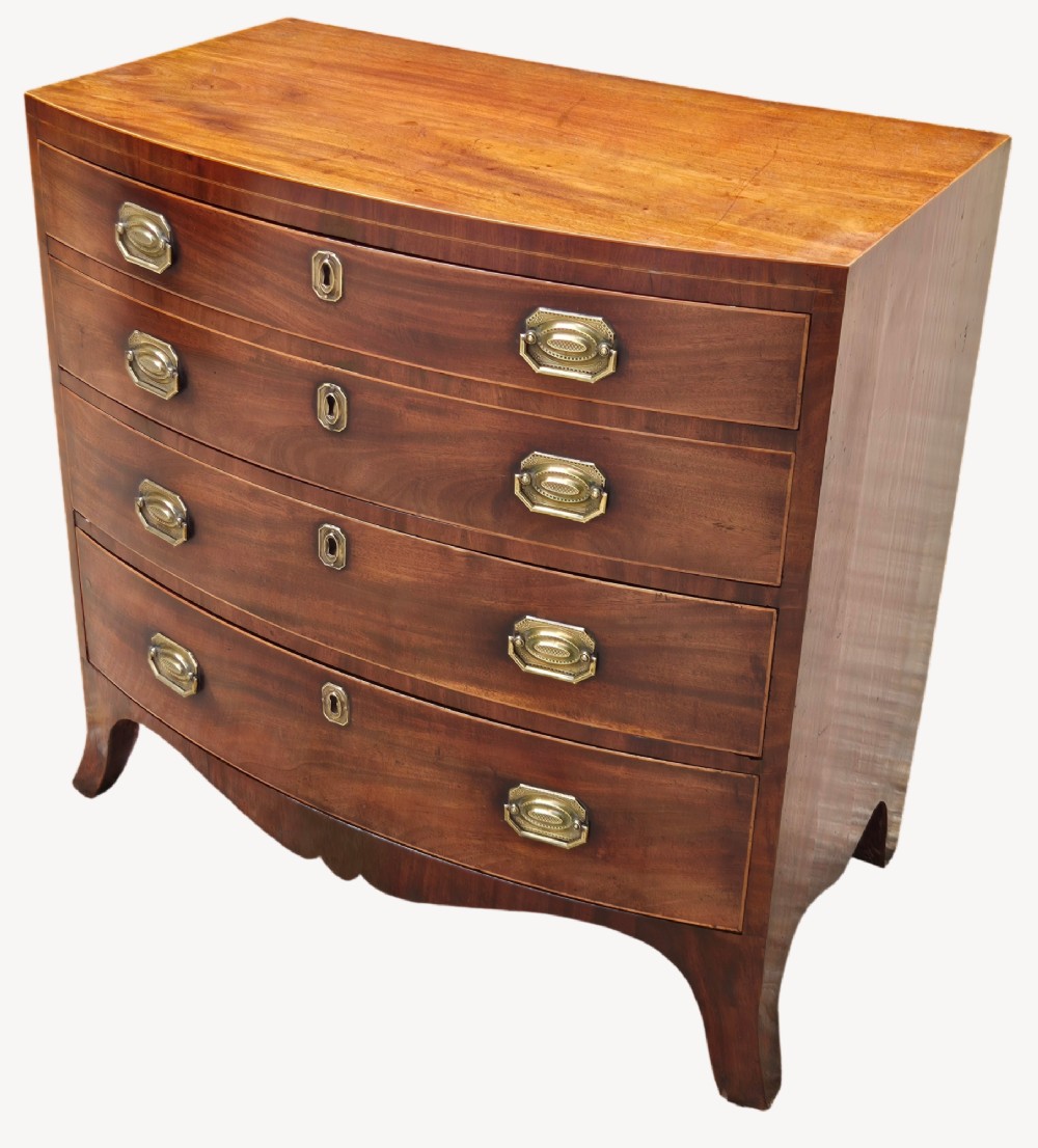 An antique mahogany bowfront chest of four graduated drawers featuring brass drop handles and splayed bracket feet.