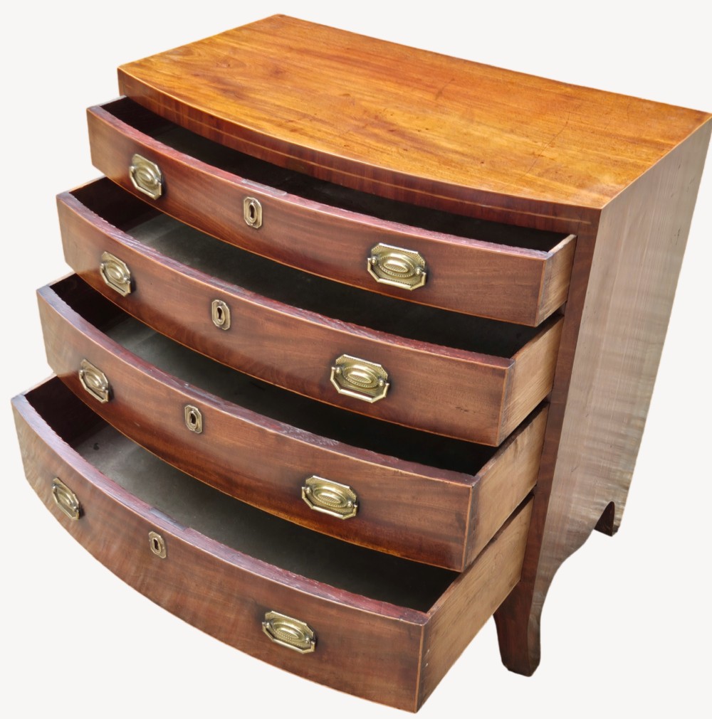 An antique mahogany bowfront chest of four graduated drawers featuring brass drop handles and splayed bracket feet. View III