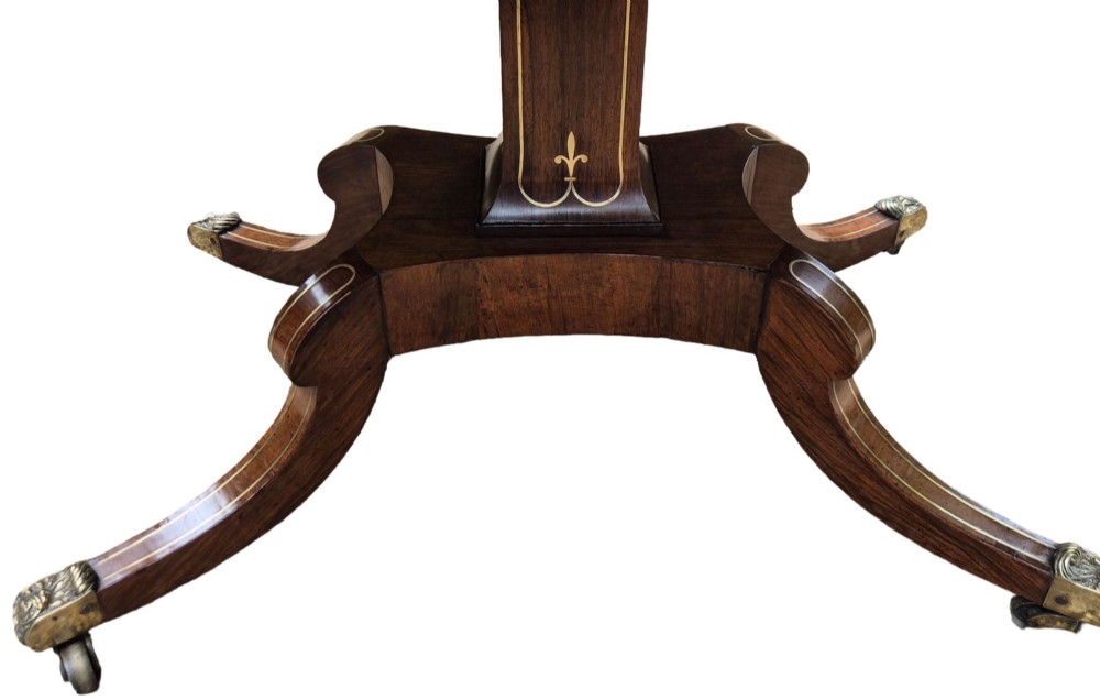 A Regency rosewood sofa table featuring hinged drop leaves, brass inlay decoration, two frieze drawers, and a quadripartite base on brass castors. View III