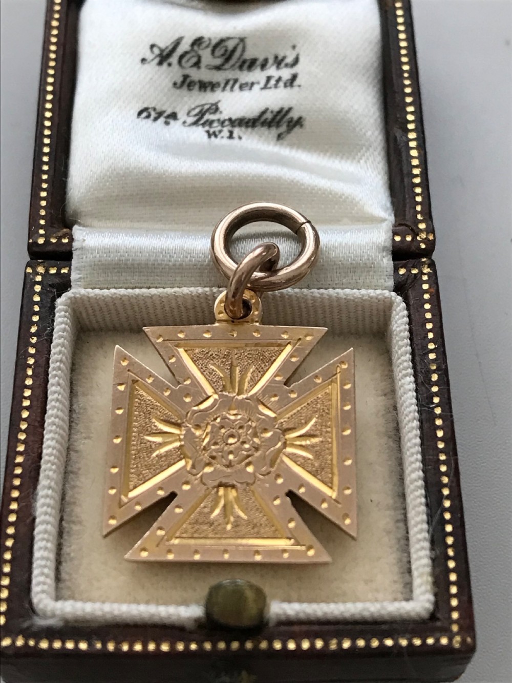 A 9ct yellow gold Maltese cross pendant featuring engraved geometric patterns, a central Tudor rose motif, and a top suspension ring. View III