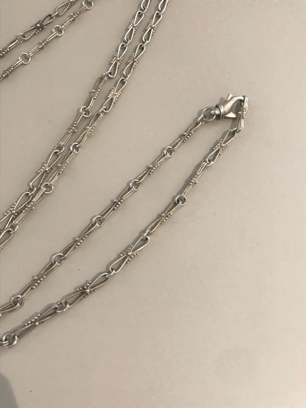 A long vintage silver chain featuring decorative fancy links with subtle beaded wire details. View III
