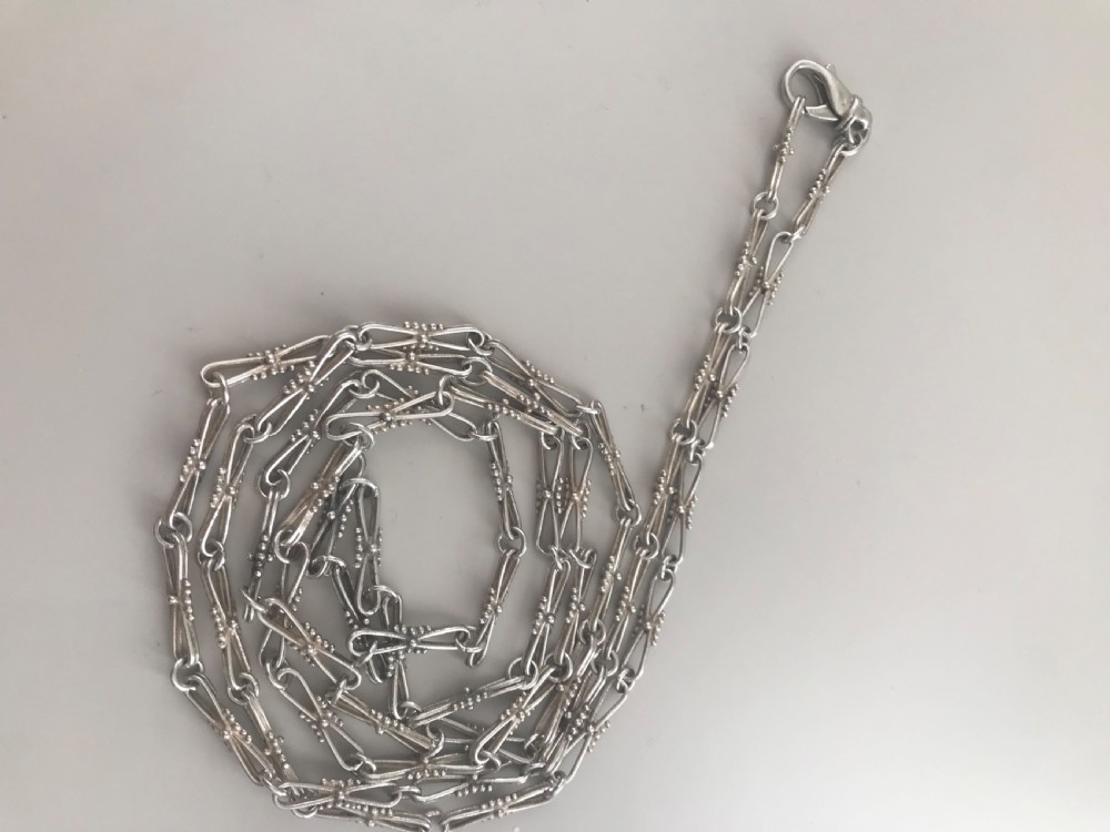 A long vintage silver chain featuring decorative fancy links with subtle beaded wire details. View IV