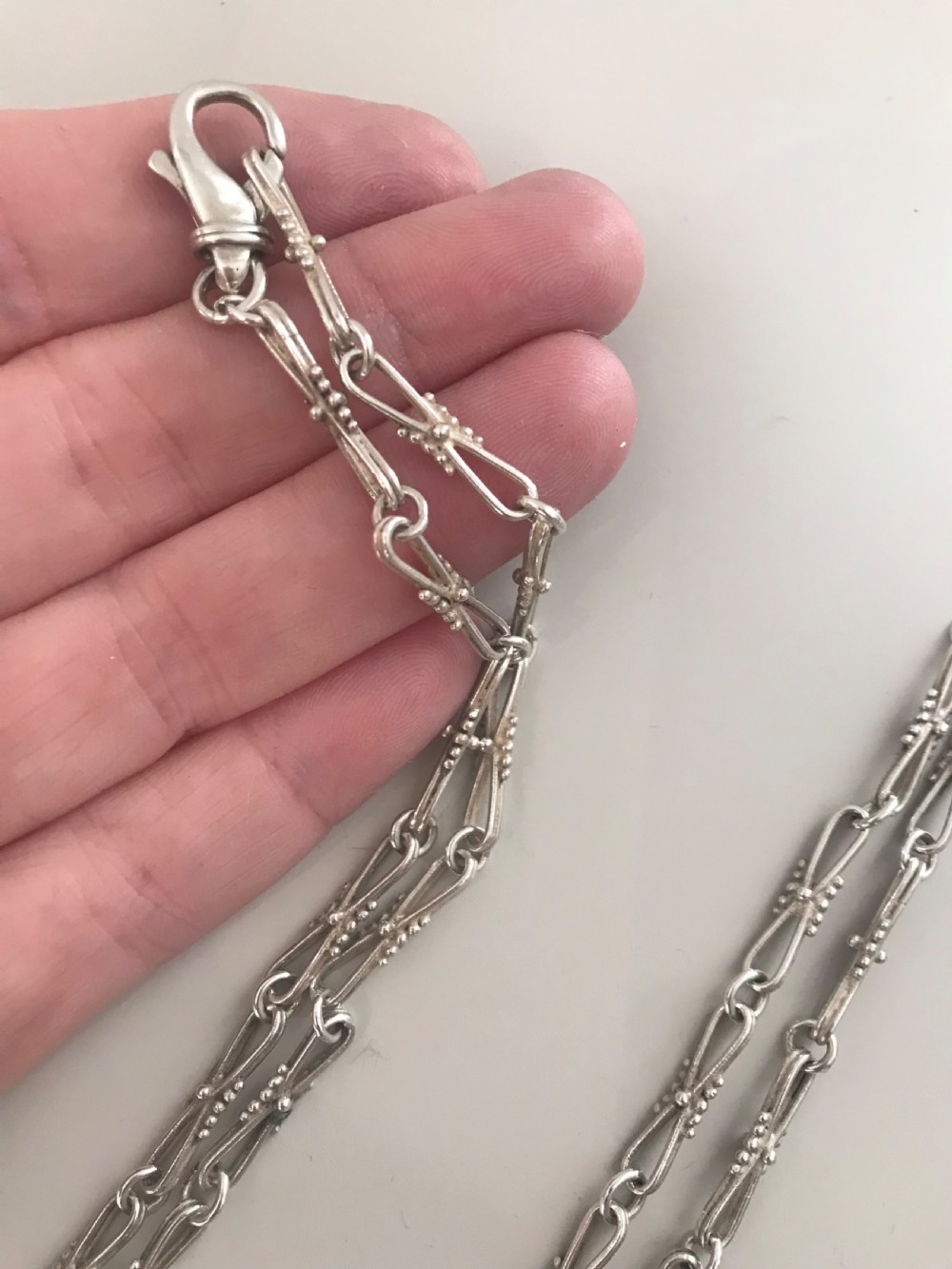 A long vintage silver chain featuring decorative fancy links with subtle beaded wire details. View V