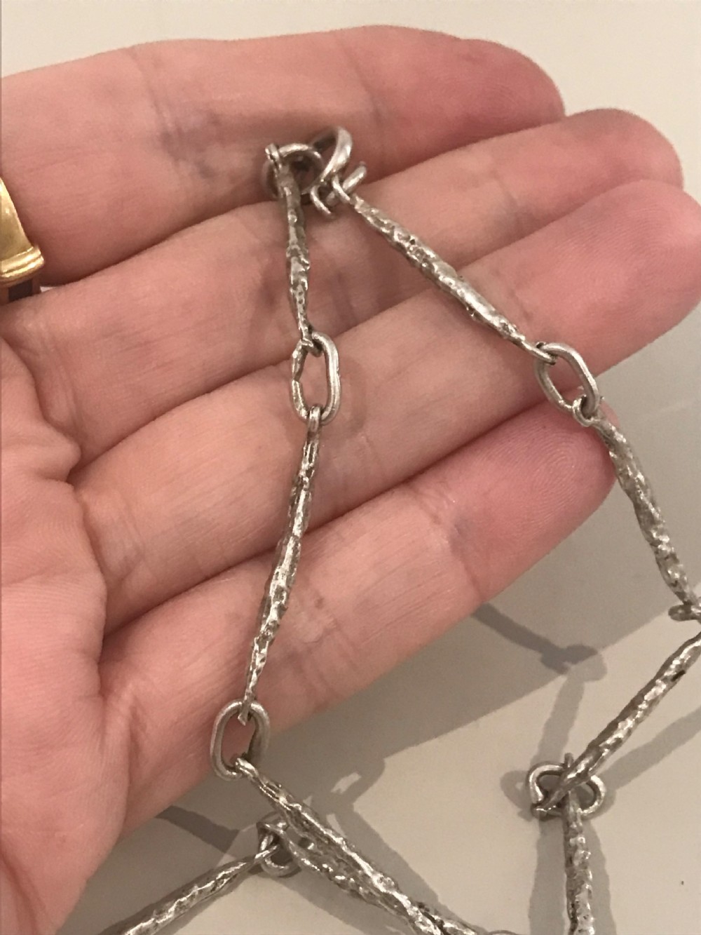 A vintage sterling silver chain necklace with elongated textured bar links presented inside a dark velvet-lined display box. View II