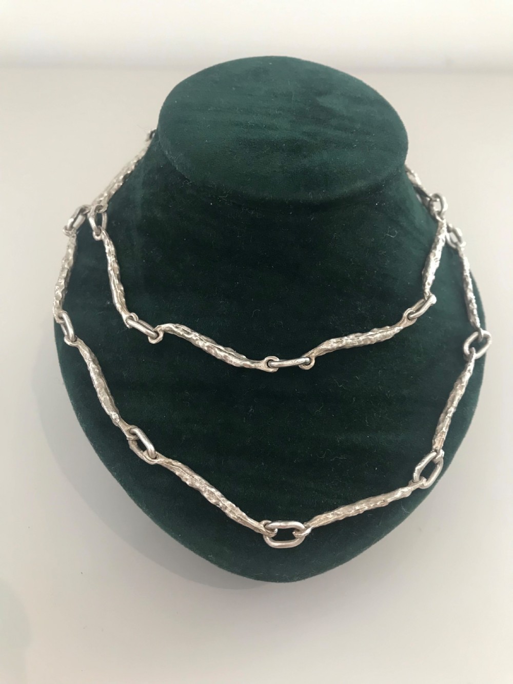 A vintage sterling silver chain necklace with elongated textured bar links presented inside a dark velvet-lined display box. View IV