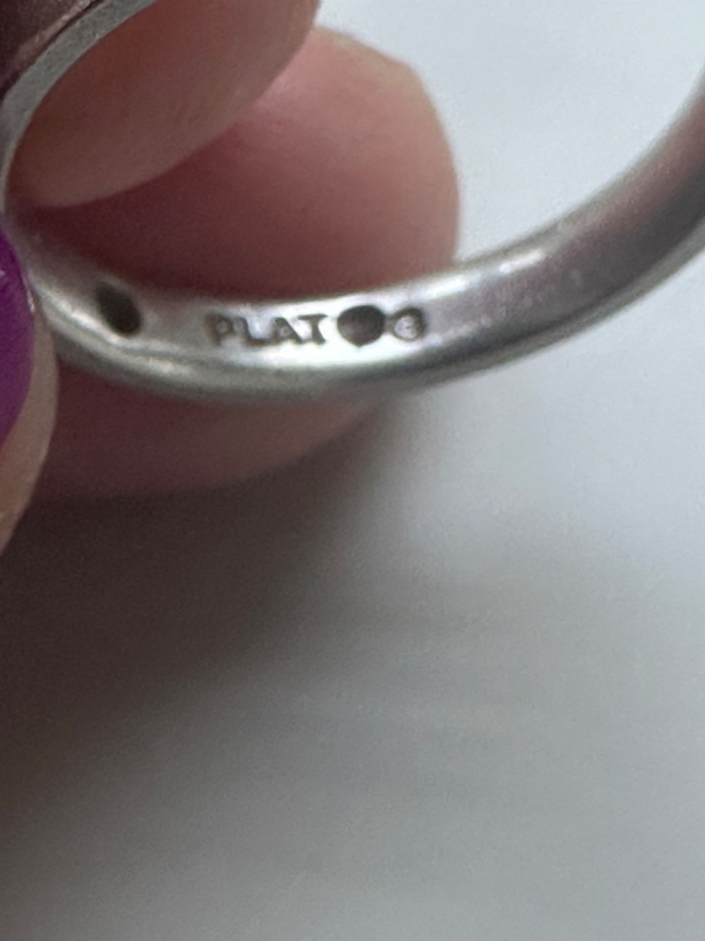 A platinum ring band inset with round diamonds sitting inside a fitted velvet presentation box. View VI