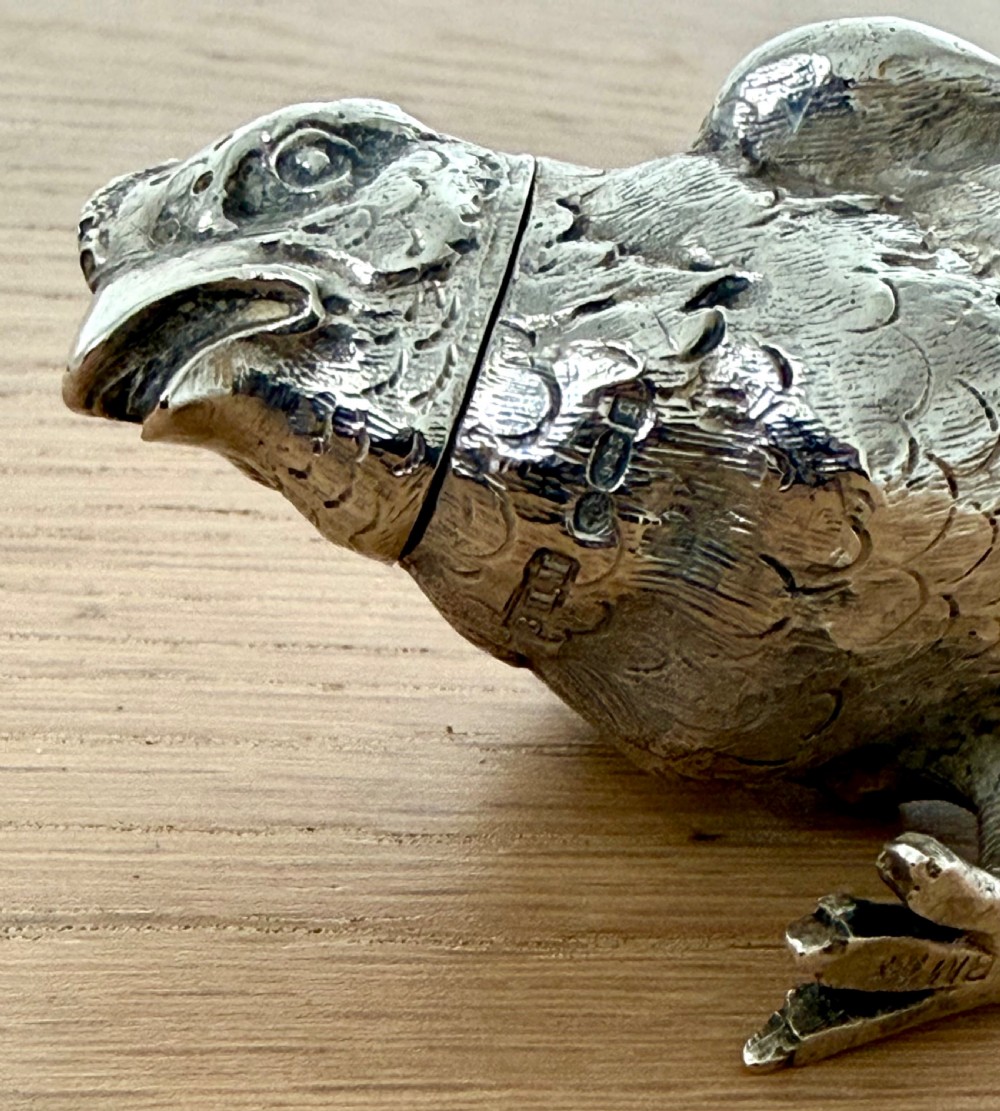 A cast silver pepper pot sculpted in the realistic shape of a chick with detailed feather engraving and a pierced head. View IX