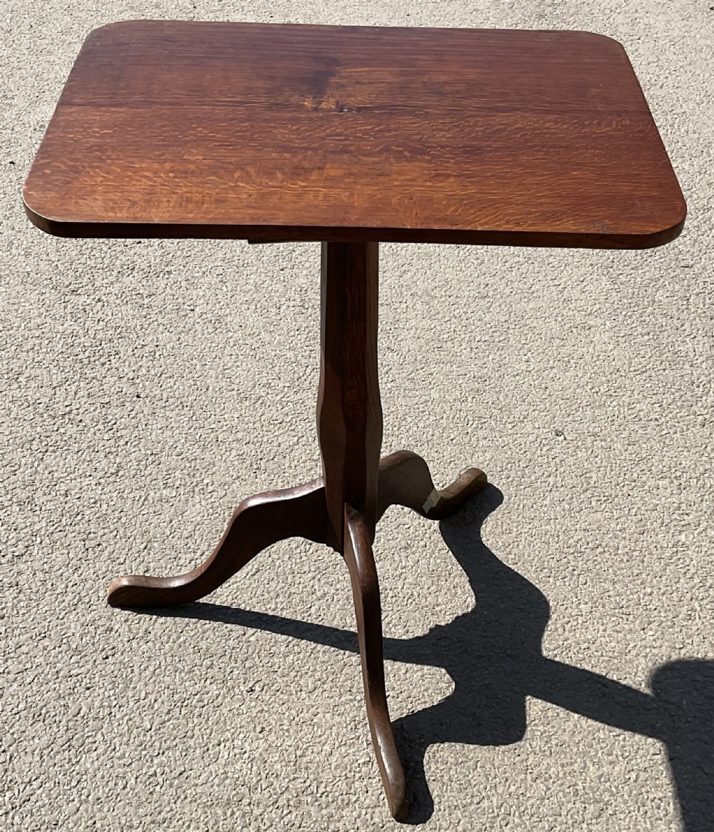A Georgian mahogany tripod table featuring a rectangular top with rounded corners, a central turned column, and three splayed cabriole legs.