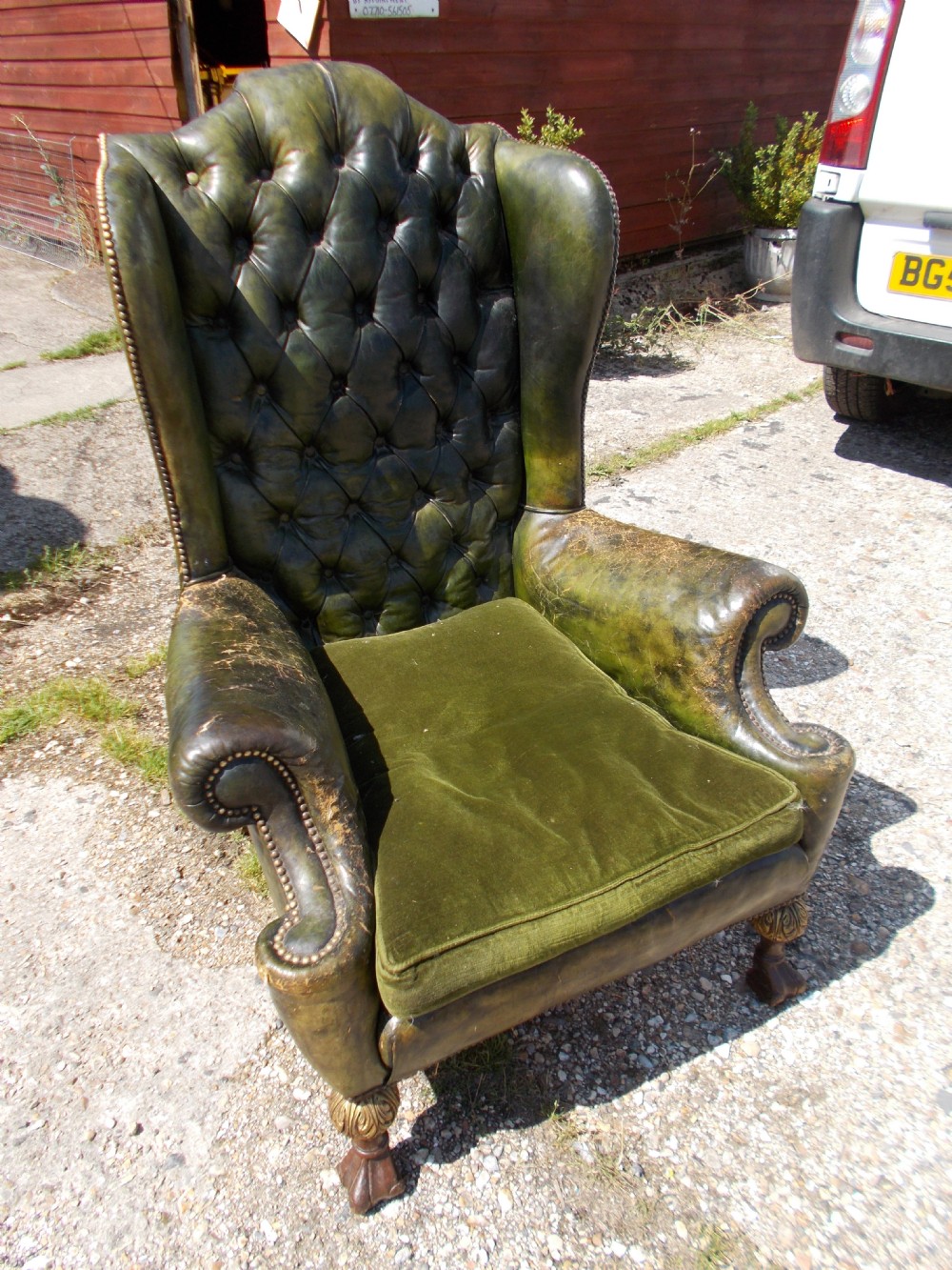 Old leather wing back upholstered armchair