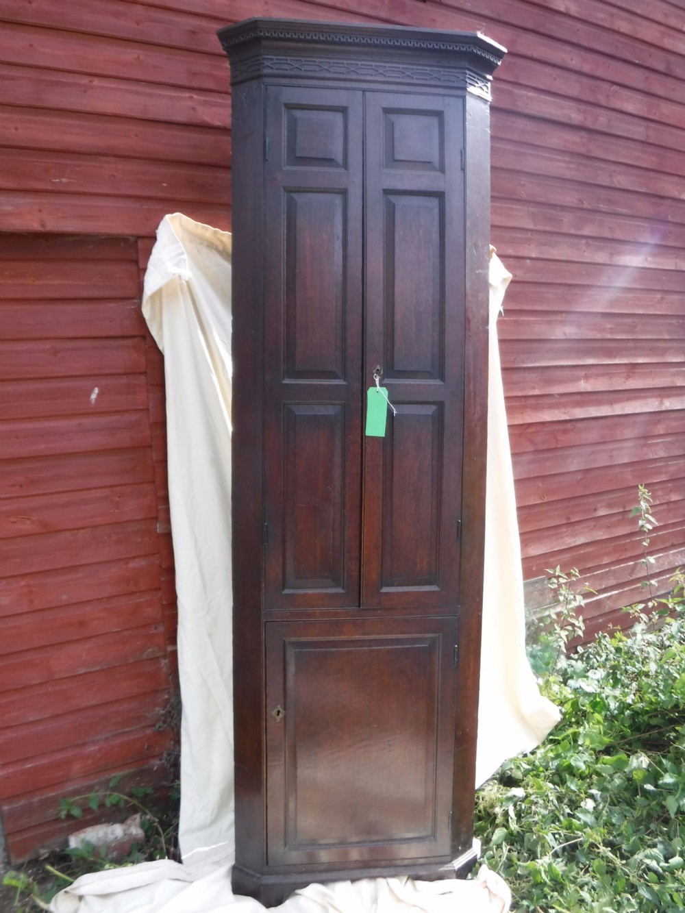 Early 19th century narrow and tall panelled oak corner cupboard.