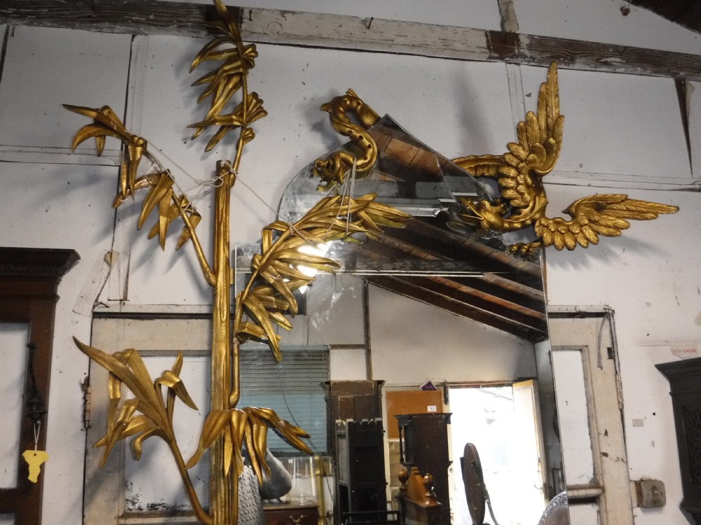 A tall giltwood hall mirror adorned with carved bamboo side pillars, mythical winged dragon motifs, and a carved shell base. View V