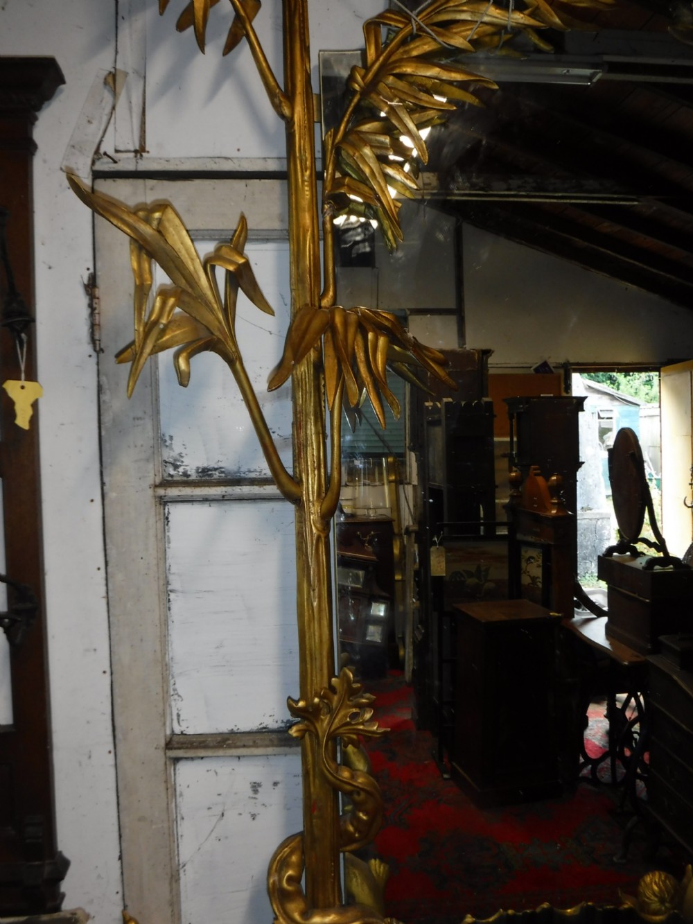 A tall giltwood hall mirror adorned with carved bamboo side pillars, mythical winged dragon motifs, and a carved shell base. View VIII