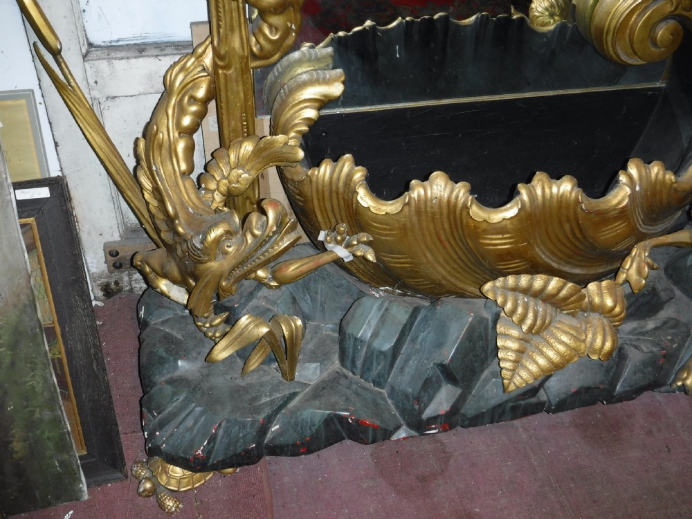 A tall giltwood hall mirror adorned with carved bamboo side pillars, mythical winged dragon motifs, and a carved shell base. View IX