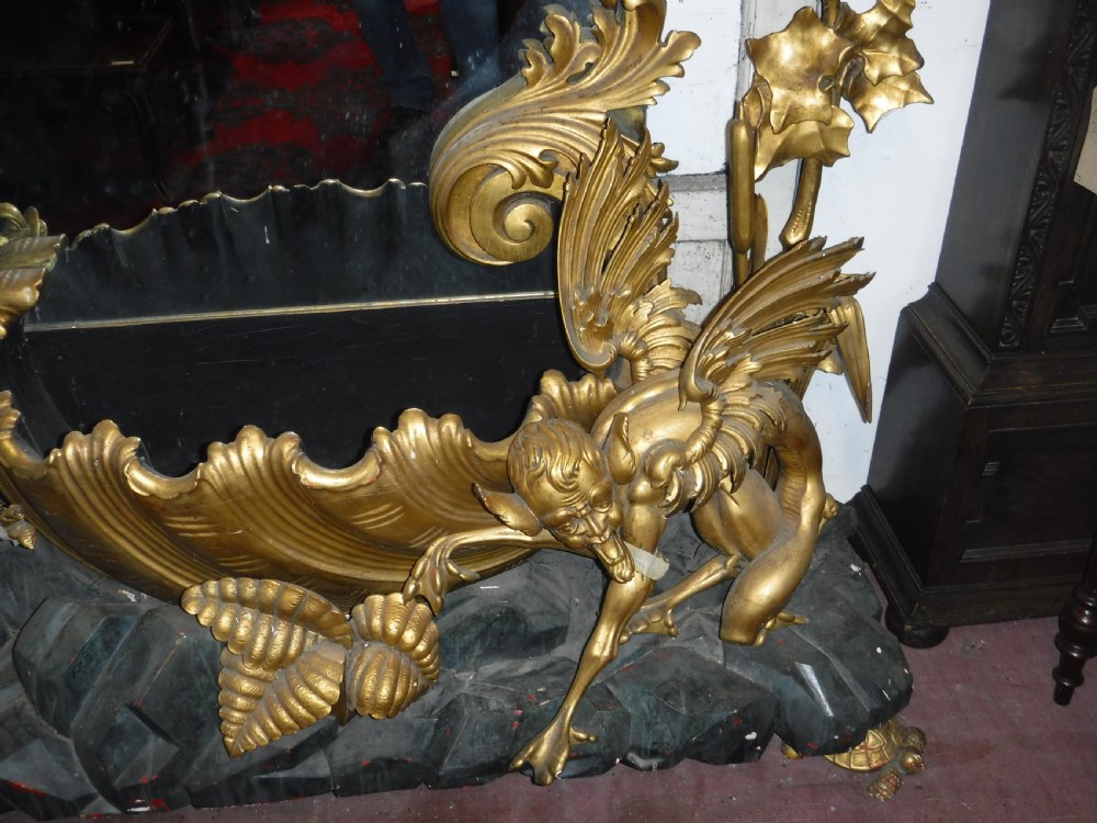 A tall giltwood hall mirror adorned with carved bamboo side pillars, mythical winged dragon motifs, and a carved shell base. View X