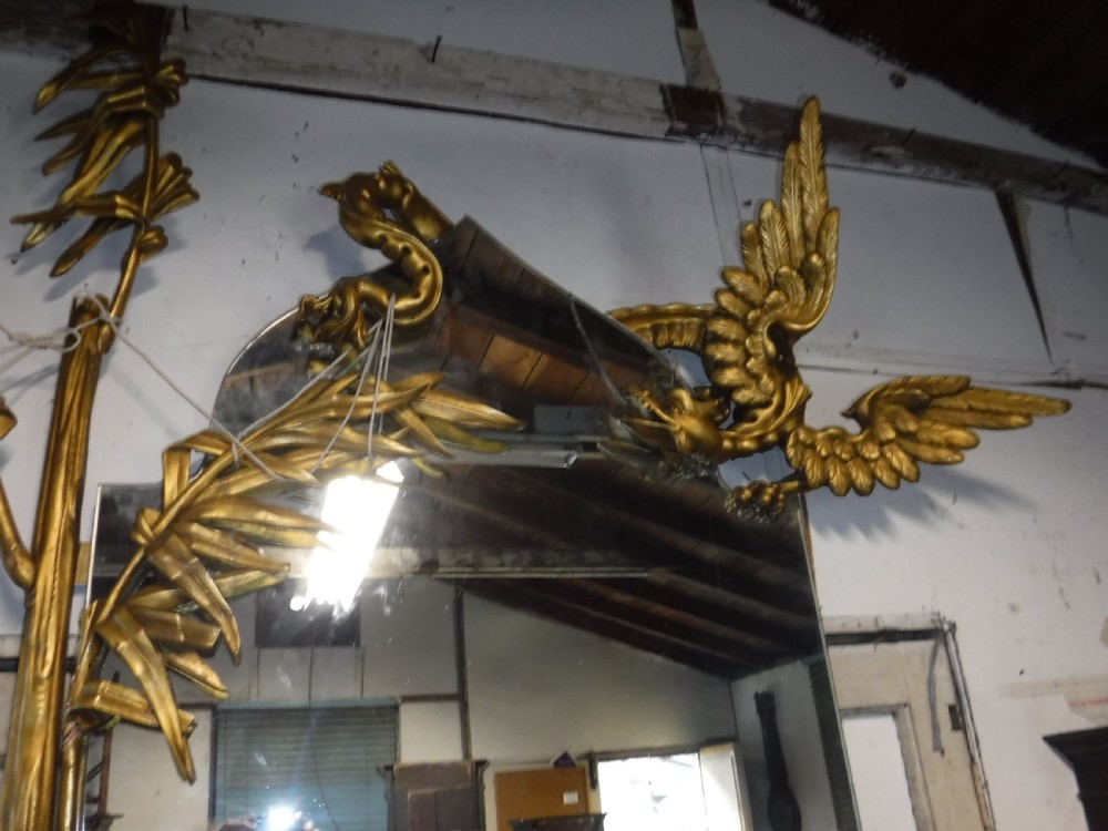 A tall giltwood hall mirror adorned with carved bamboo side pillars, mythical winged dragon motifs, and a carved shell base. View XIV