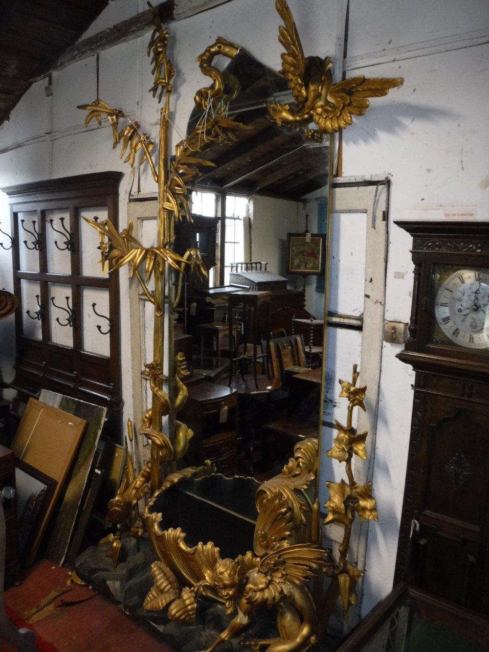 A tall giltwood hall mirror adorned with carved bamboo side pillars, mythical winged dragon motifs, and a carved shell base. View XVI