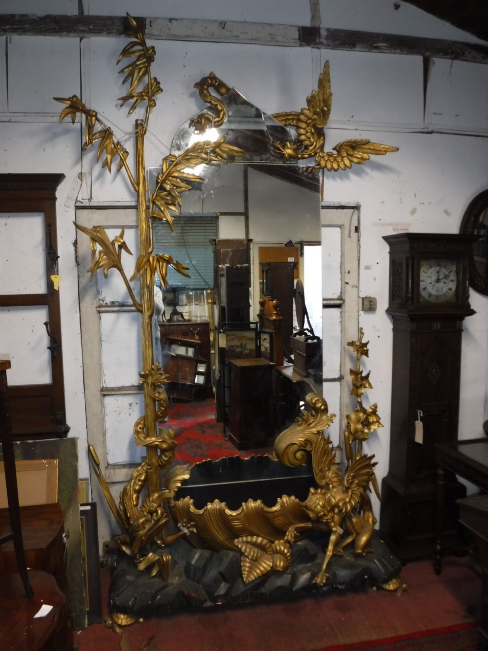A tall giltwood hall mirror adorned with carved bamboo side pillars, mythical winged dragon motifs, and a carved shell base. View XVII