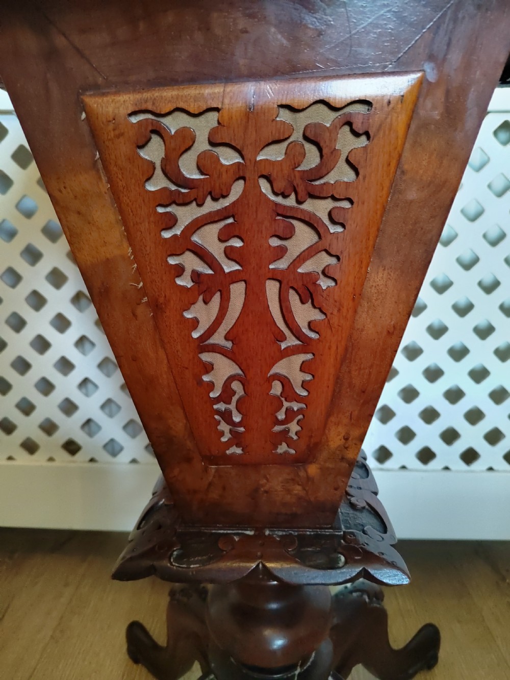 A Victorian wooden trumpet sewing table with an inlaid top, fretwork column, and carved tripod base. View IV
