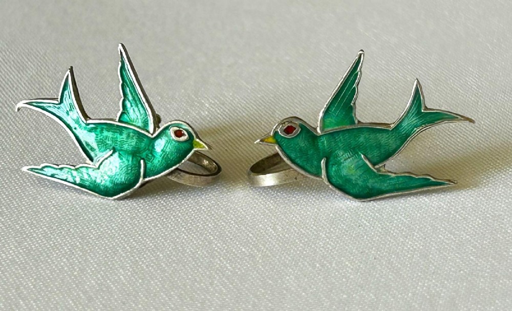 Pair of Edwardian sterling silver earrings shaped as swallows in flight with vibrant green enamel wings and body.